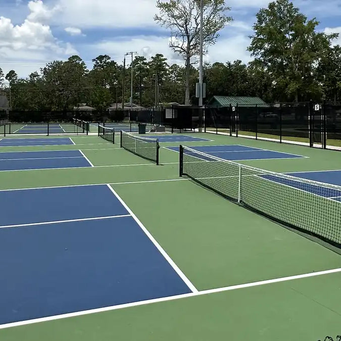 Row of outdoor pickleball courts with blue and green acrylic hard court surface