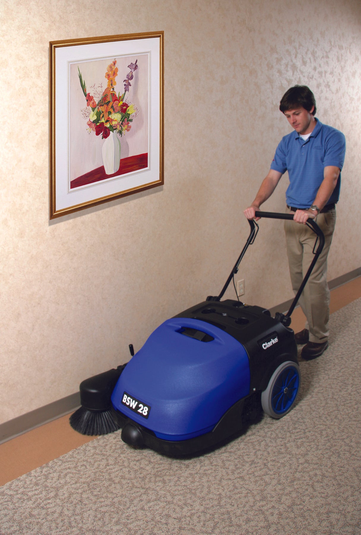 Clarke® BSW 28" Floor Sweeper - Front Left angle being used by operator near the walls.
