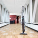 Nilfisk Dryft Floor Scrubber Hero Image viewed from a front left angle, in a corridor with wooden hard floors
