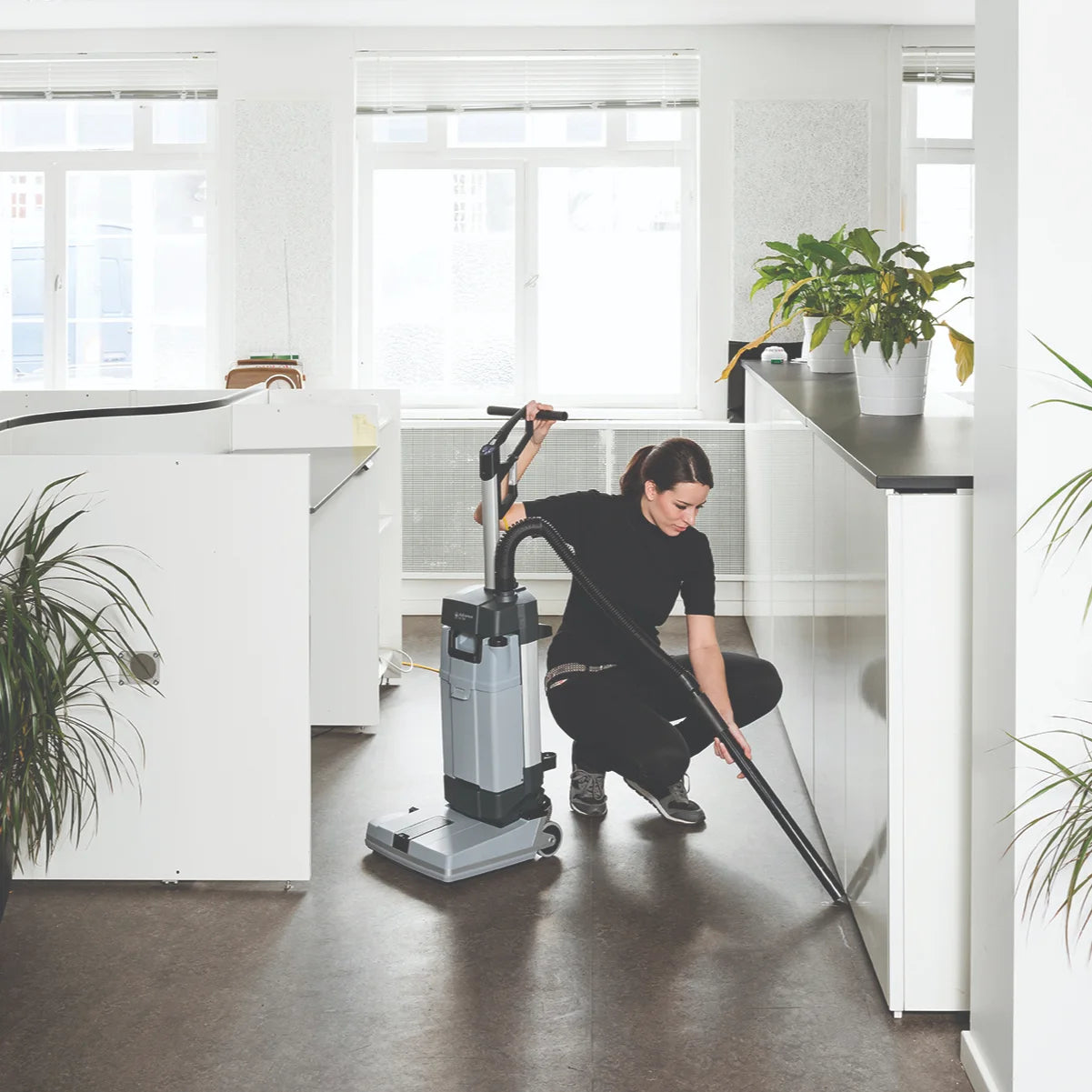Cleaning under an office counter with the SC100 manual suction hose