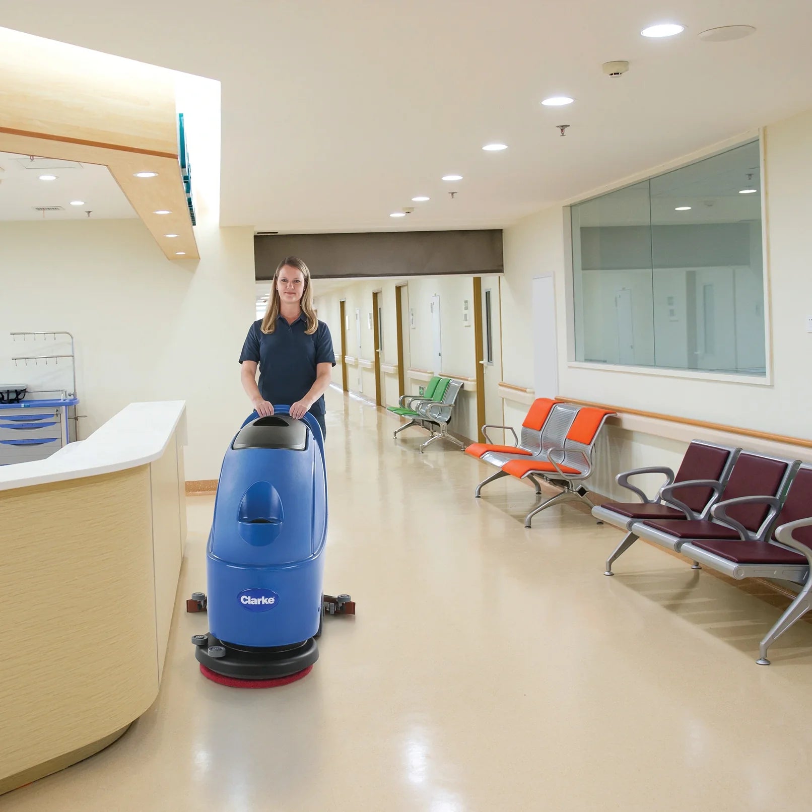 Custodian scrubbing a hard floor with the Clarke CA30 17E corded floor scrubber in a healthcare facility