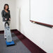Operator vacuuming commercial carpet with a Clarke CarpetMaster 112