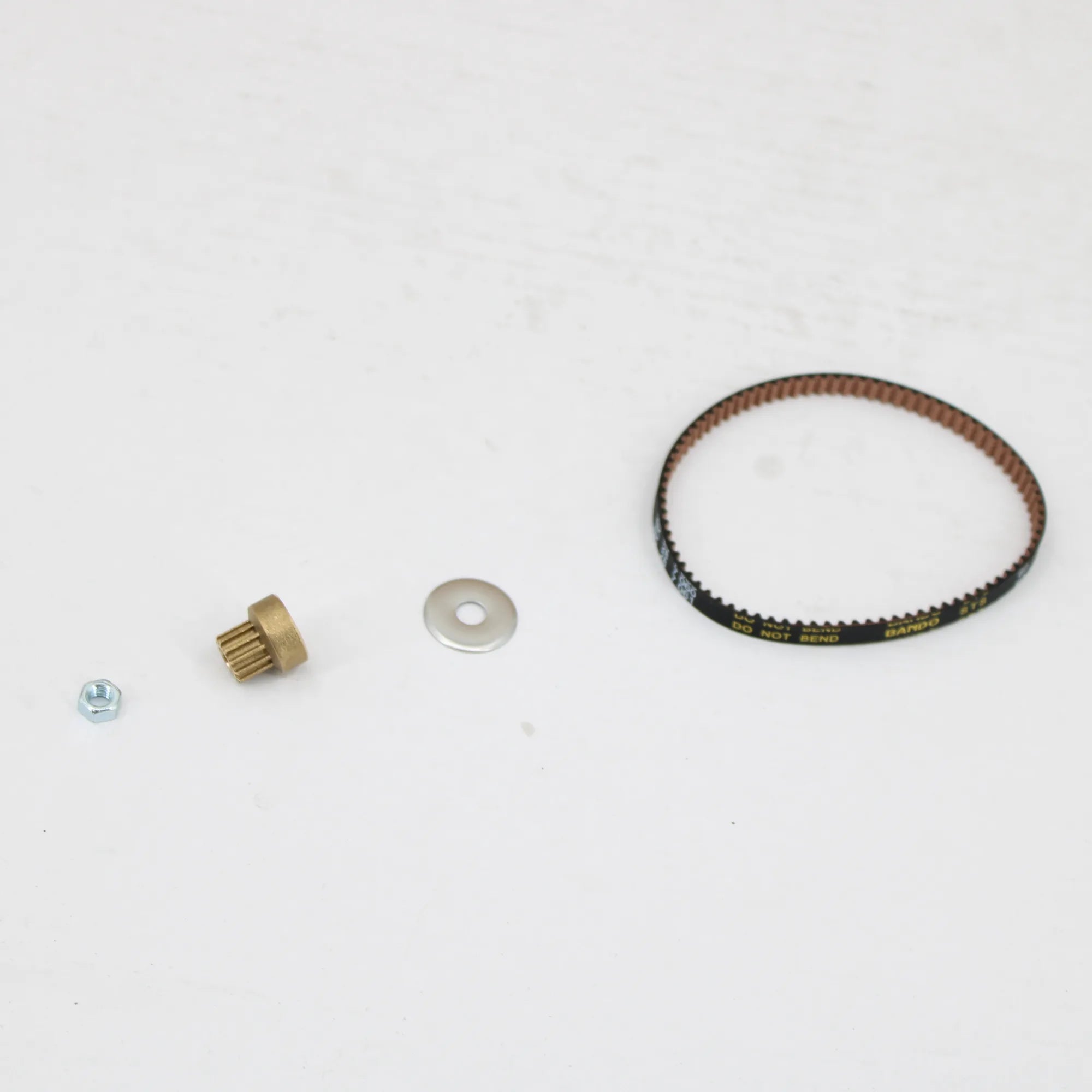 Parts of the Clarke drive belt kit 1470905510 laid out: belt, gear, washer and nut