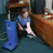 Housekeeper detailing a hotel room with the quick-draw wand of a Clarke CarpetMaster 212