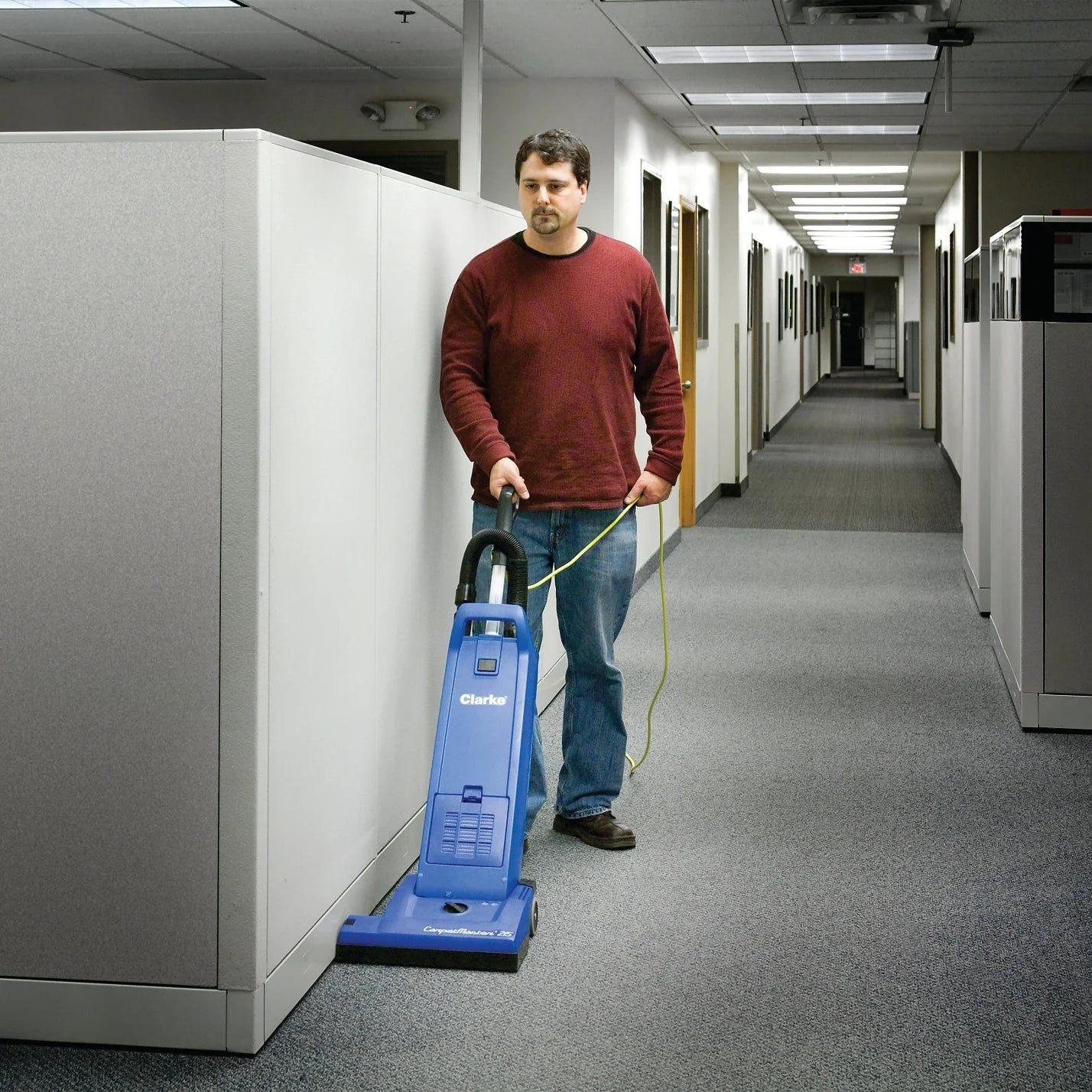 Clarke CarpetMaster 215 vacuuming carpet along the wall of an office hallway