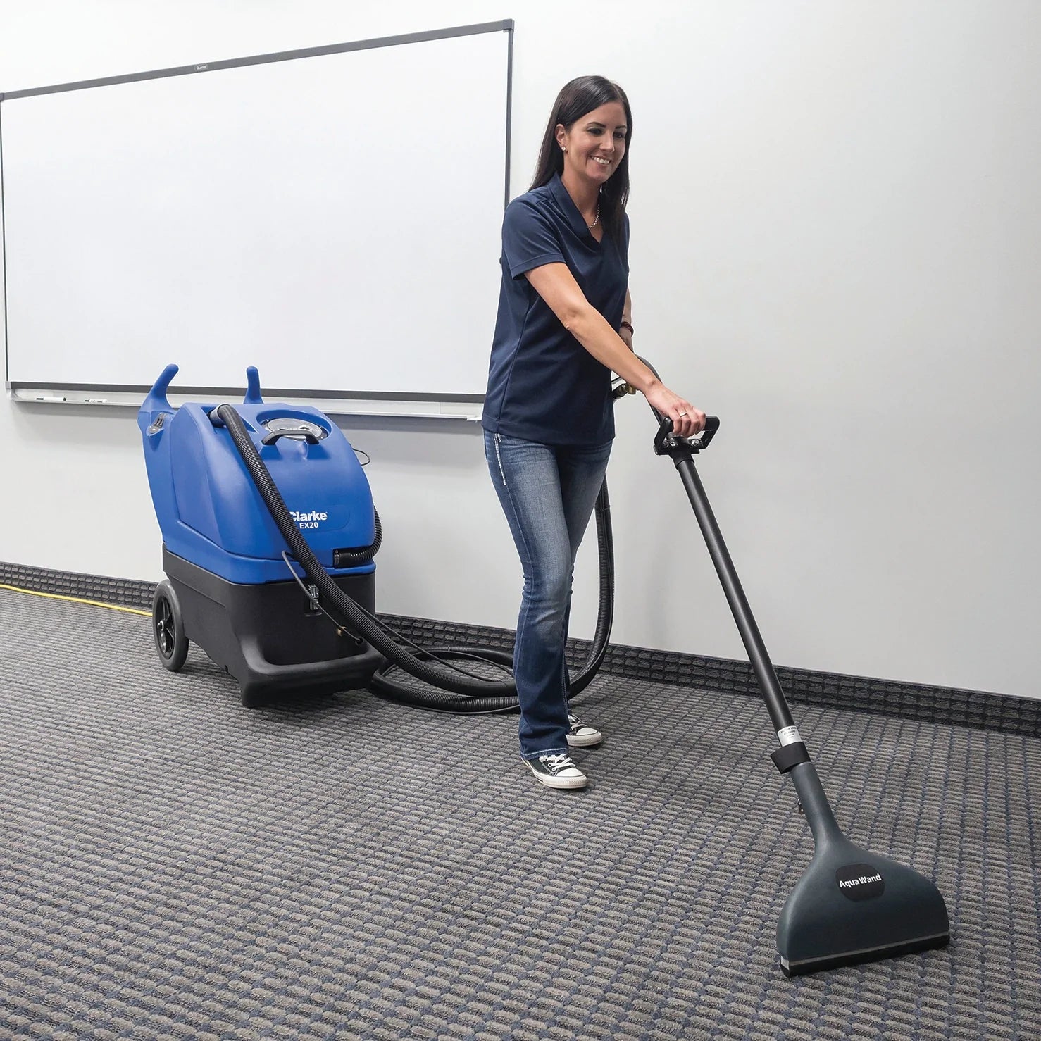 Clarke EX20 portable carpet extractor cleaning the carpet of an office training room
