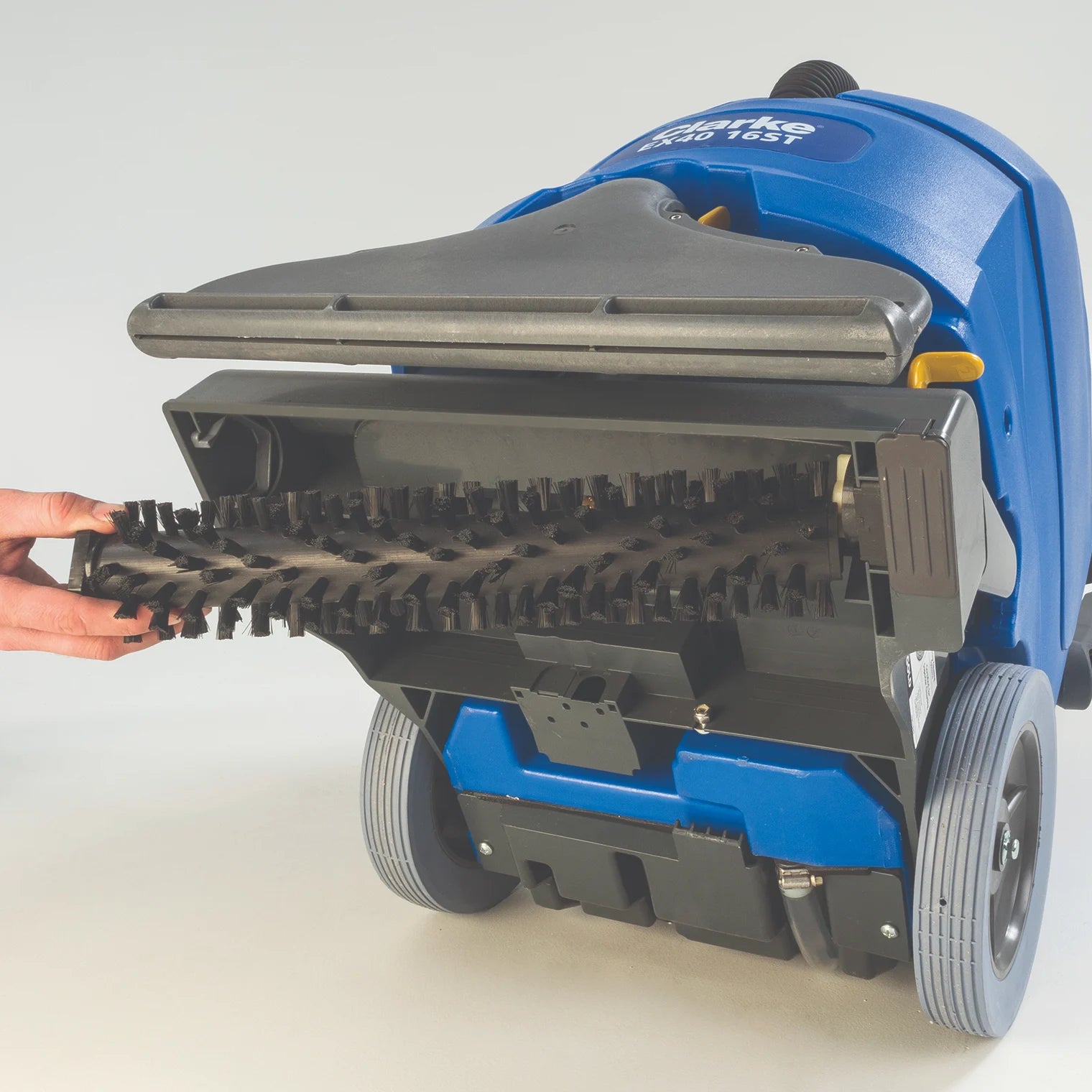 Removing the brush from a Clarke EX40 carpet extractor tipped on its back