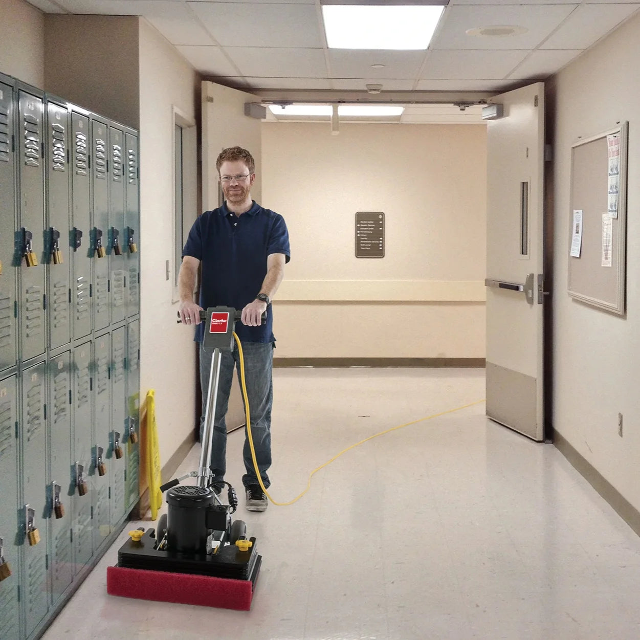 Operator running the Clarke FM40 LX orbital floor machine in a school hallway