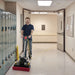 Operator running the Clarke FM40 LX orbital floor machine in a school hallway