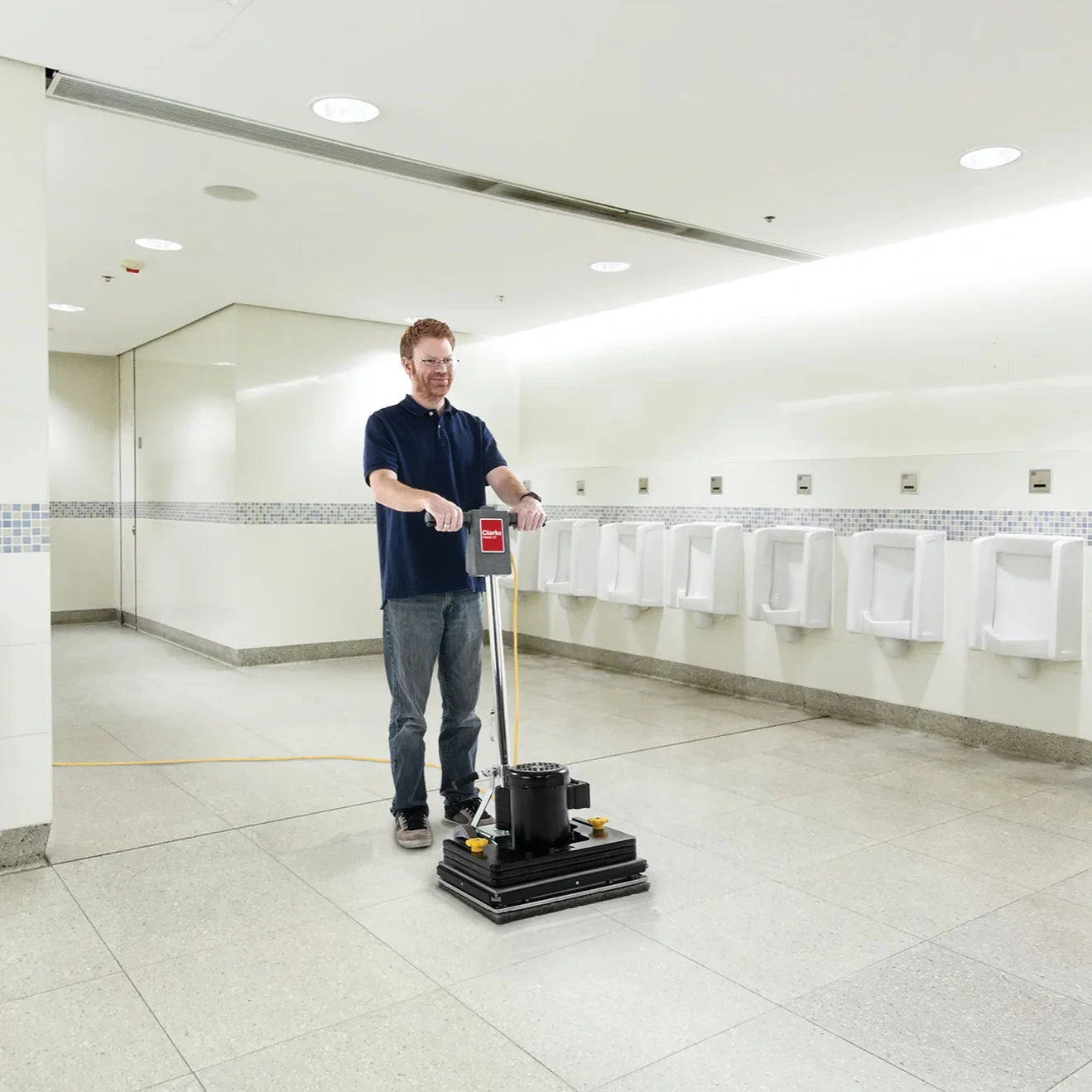 Clarke FM40 ST orbital floor machine scrubbing a restroom floor