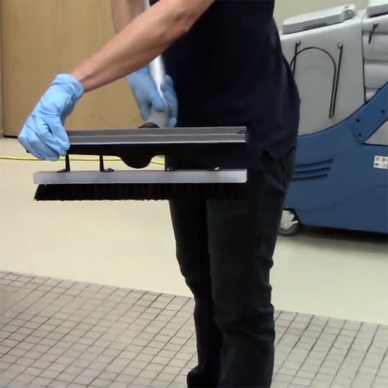Scrubbing a restroom floor with the EDIC dual head wand on a CR2