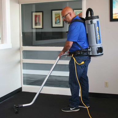 EDIC Atlas backpack vacuum worn by an operator vacuuming commercial carpet