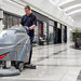 Operator scrubbing a shopping mall concourse with the ICE i28BTL+ walk-behind floor scrubber