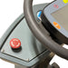 Close-up of the red emergency stop button on the dash of an ICE rider scrubber, beside the steering wheel and touch panel