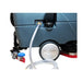 Clear fill hose plugged into the solution tank port on the side of an ICE rider scrubber, above the rear wheel