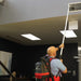 Worker using the NaceCare high-level dusting kit to clean a ceiling