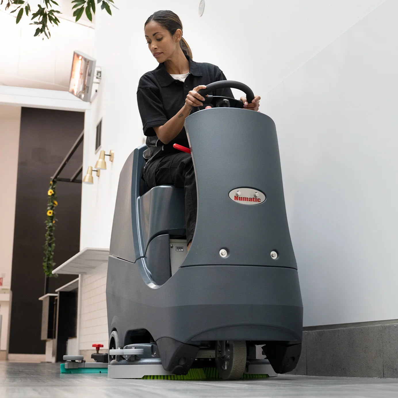 NaceCare CRL 2128 compact ride-on scrubber cleaning a commercial floor