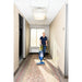 Housekeeper vacuuming a carpeted hotel corridor with a NaceCare upright vacuum