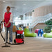Custodian vacuuming carpet in a modern office lounge with the cordless NBV 290NX