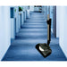 NaceCare battery power brush vacuuming a carpeted office hallway