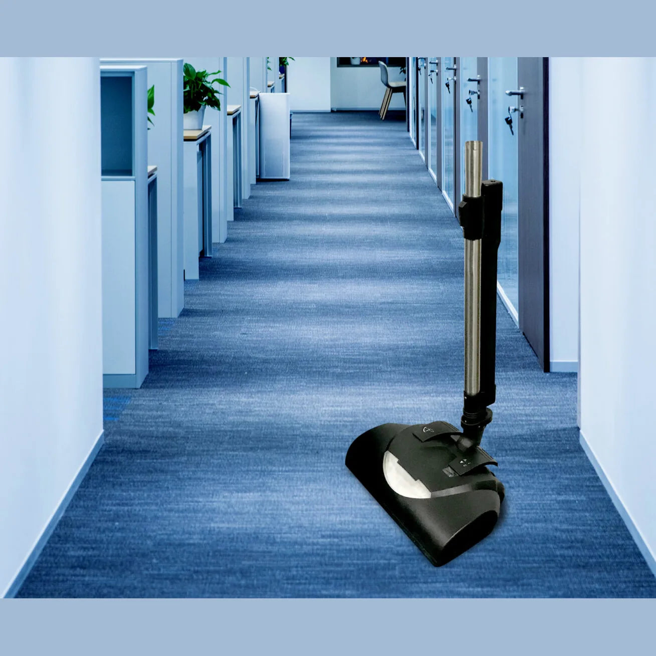 NaceCare vacuum with the battery power brush on a blue carpeted office hallway between cubicles