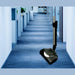 NaceCare vacuum with the battery power brush on a blue carpeted office hallway between cubicles