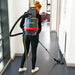 Woman vacuuming a floor with the NaceCare RSV 150 backpack vacuum