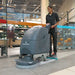 Operator scrubbing a grocery store floor near the entrance with the NaceCare TBL 1120