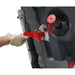 Gloved hand pulling the red-capped drain hose out of the side of the TBL 2228T