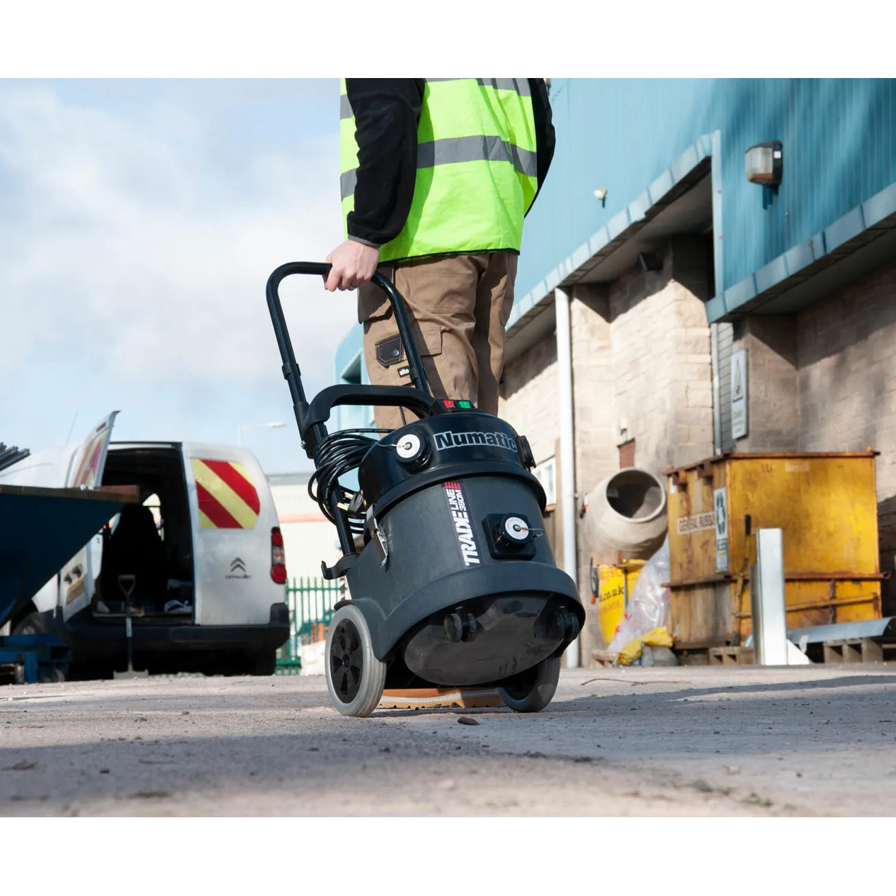 Worker pulling the TEL 390 by its trolley handle across a jobsite