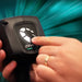 Hand pressing the button on the Nilfisk Dryft battery to light up its charge level display