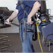 Operator wearing a Comfort Pro backpack vacuum in a meeting room, with tools on the waist belt and the power cord at the hip