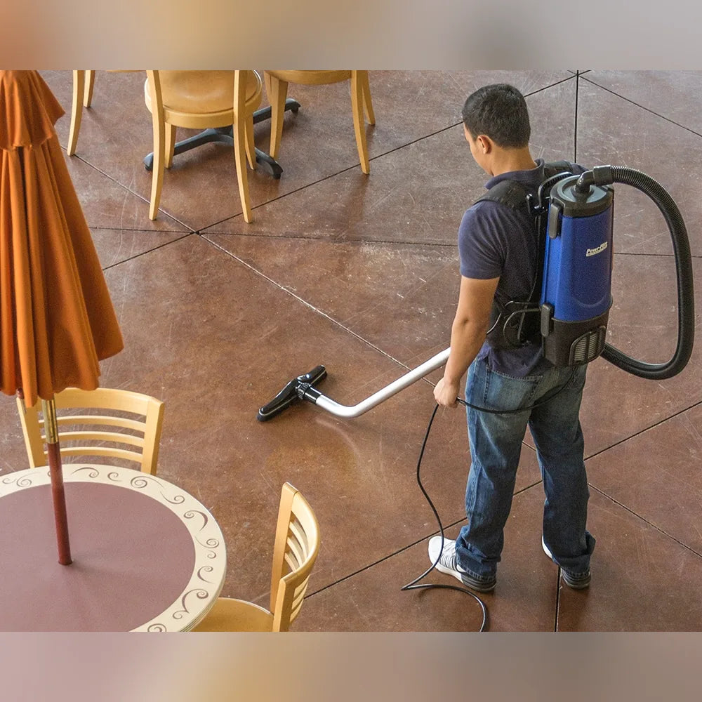 Cleaner using the Pro-Lite BP4S floor tool on a stained concrete cafe floor