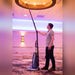 Cleaner dusting a lobby ceiling light with the Rigel Deluxe hose and telescopic wand