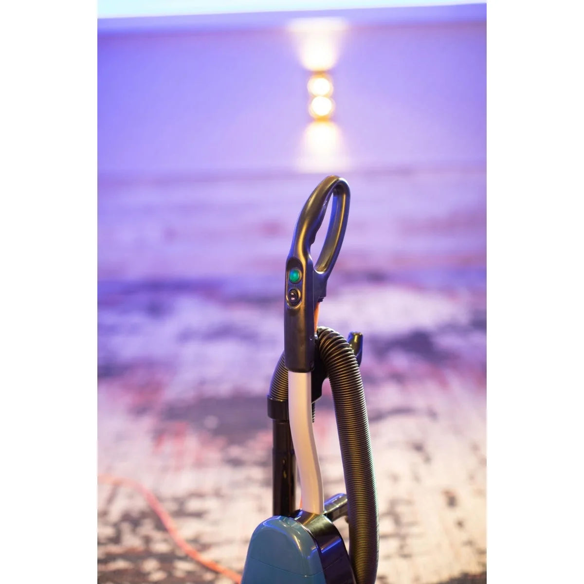 Powr-Flite Rigel Pro upright vacuum parked on hotel room carpet, handle close-up