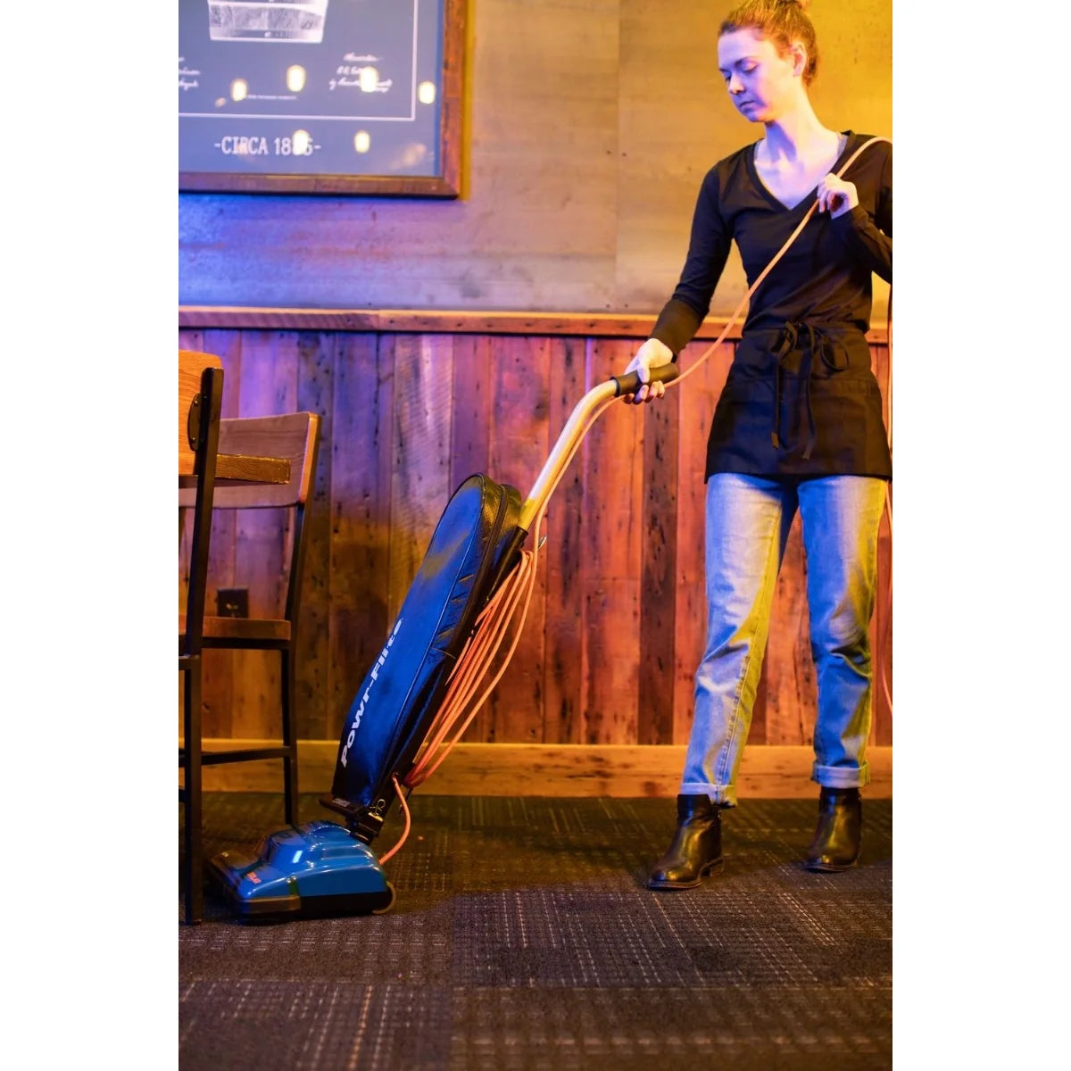 Woman vacuuming a carpeted room with the Powr-Flite Solar upright